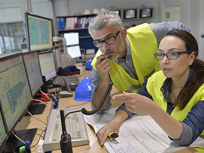 Man and woman monitoring on computers.