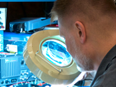 Man looking through magnifier.