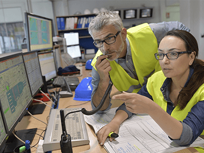 Man and woman monitoring on computers.
